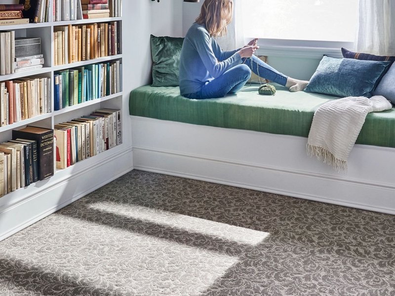 Lady relaxing on window bench with carpet flooring