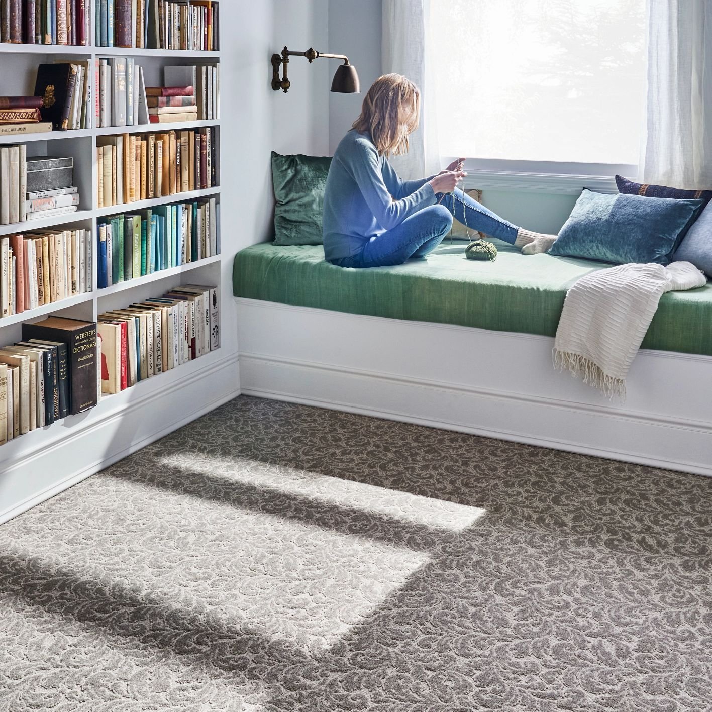 Lady relaxing on window bench with carpet flooring